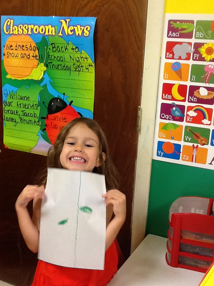 Child in our daycare program showing off her growing leaf drawing