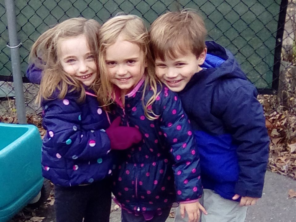 prekindergarten girls and boy on playground smiling