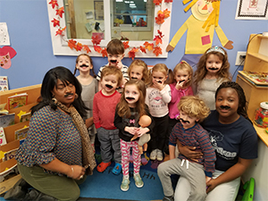 preschool class enjoying a silly picture with mustashe